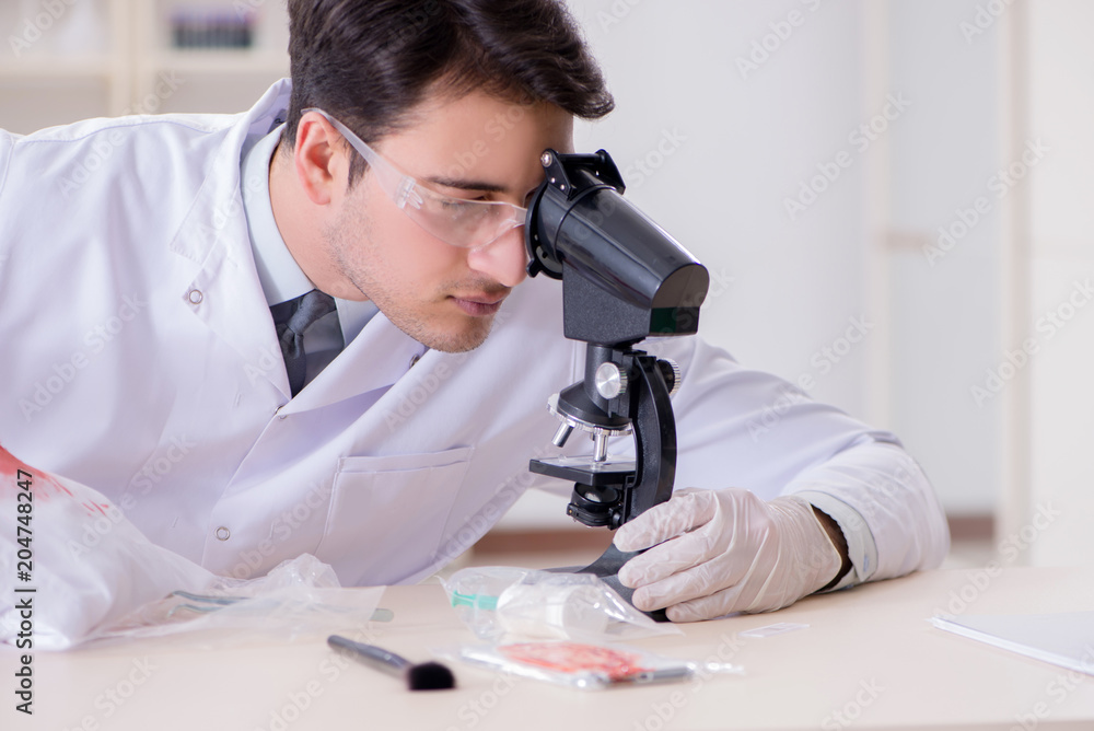 Expert criminologist working in the lab for evidence Expert criminologist working in the lab for evidence