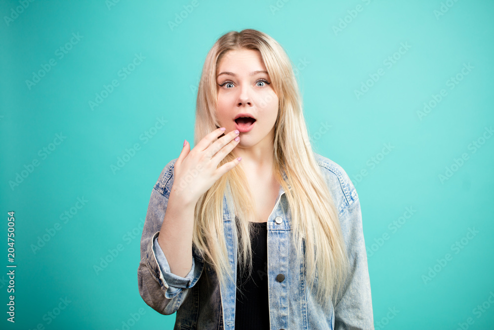 Puzzled shocked female with bugged eyes looking at camera, being surprised to hear about sale in clothing shop, isolated over blue studio background. Puzzled shocked female with bugged eyes looking at camera, being surprised to hear about sale in clothing shop, isolated over blue studio background.