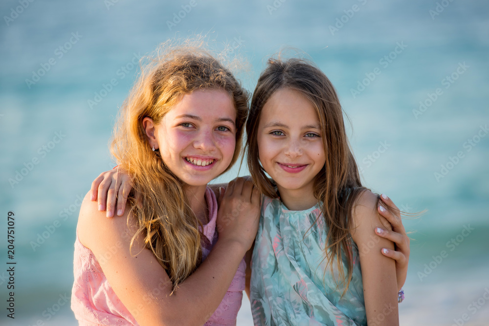 Two young girl friends on the beach