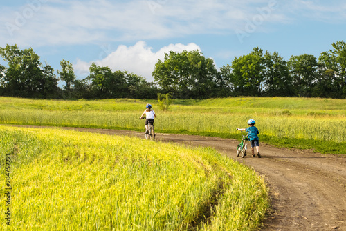 children on bicycle in rural landscape © Kotangens