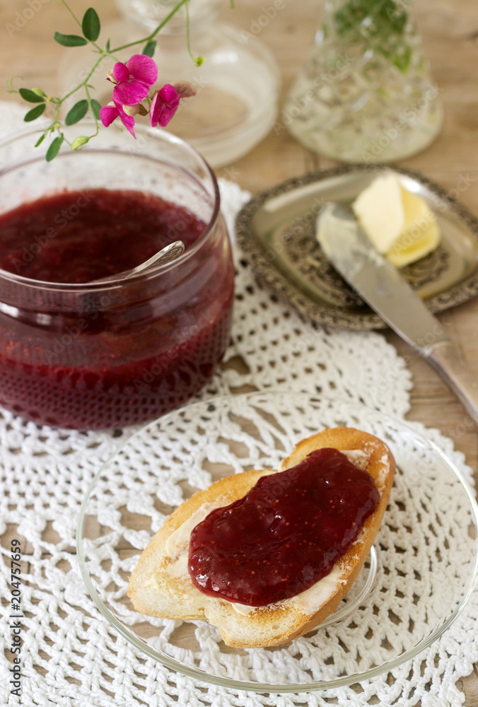 Strawberry jam in a glass jar and toast with butter and jam. Rustic style. Strawberry jam in a glass jar and toast with butter and jam. Rustic style.