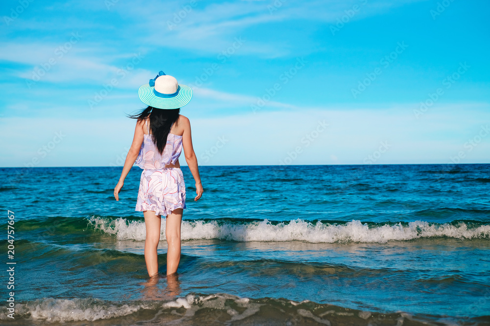 woman traveler in bikini enjoying for view of the beautiful sea on her holiday.beautiful Lady tourist walking on the beach. woman traveler in bikini enjoying for view of the beautiful sea on her holiday.beautiful Lady tourist walking on the beach.