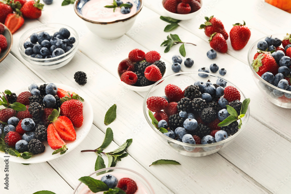 Healthy breakfast with berries and yogurt on white wooden table Healthy breakfast with berries and yogurt on white wooden table