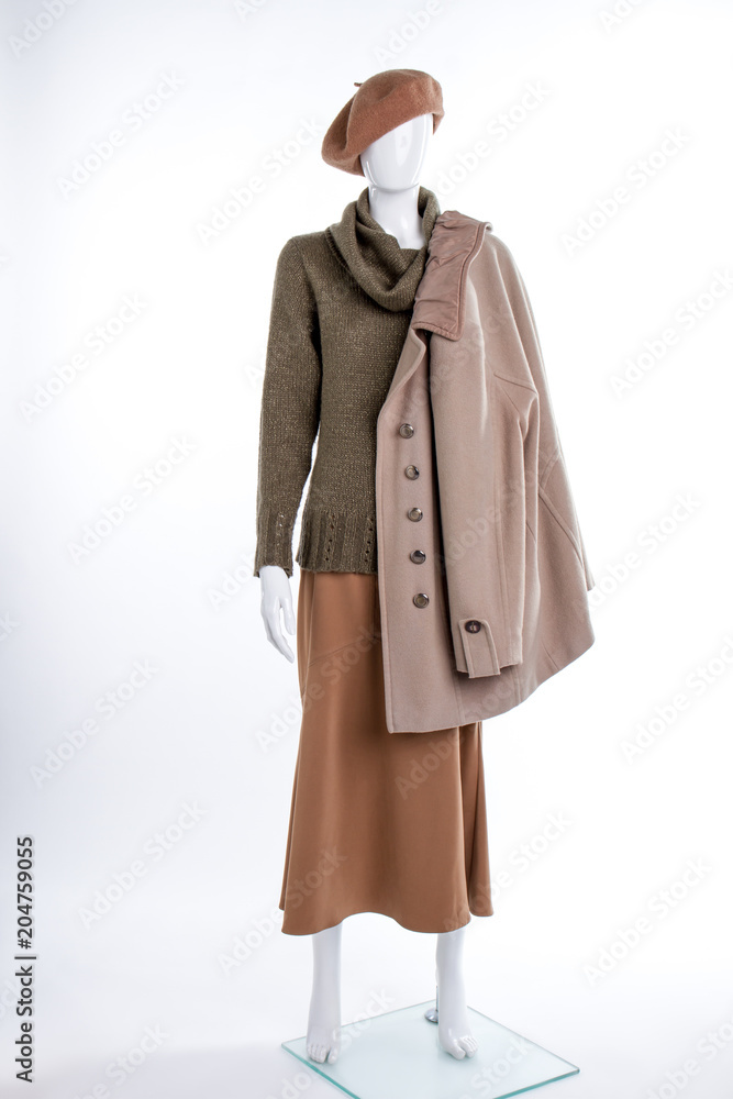 Female beret and coat on mannequin. Female mannequin with beret, sweater, skirt and overcoat. Female autumn outfit. Female beret and coat on mannequin. Female mannequin with beret, sweater, skirt and overcoat. Female autumn outfit.