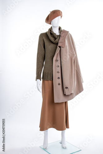 Female beret and coat on mannequin. Female mannequin with beret, sweater, skirt and overcoat. Female autumn outfit.