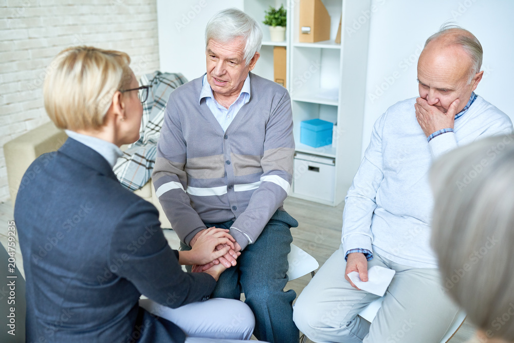 Obraz premium Careful and kind therapist giving consultation and consolation to senior patients on meeting in assisted living center.
