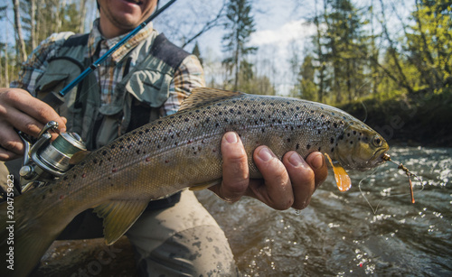 Fisherman holding brown trout