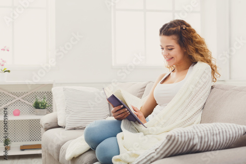 Cozy home. Young thoughtful woman with book
