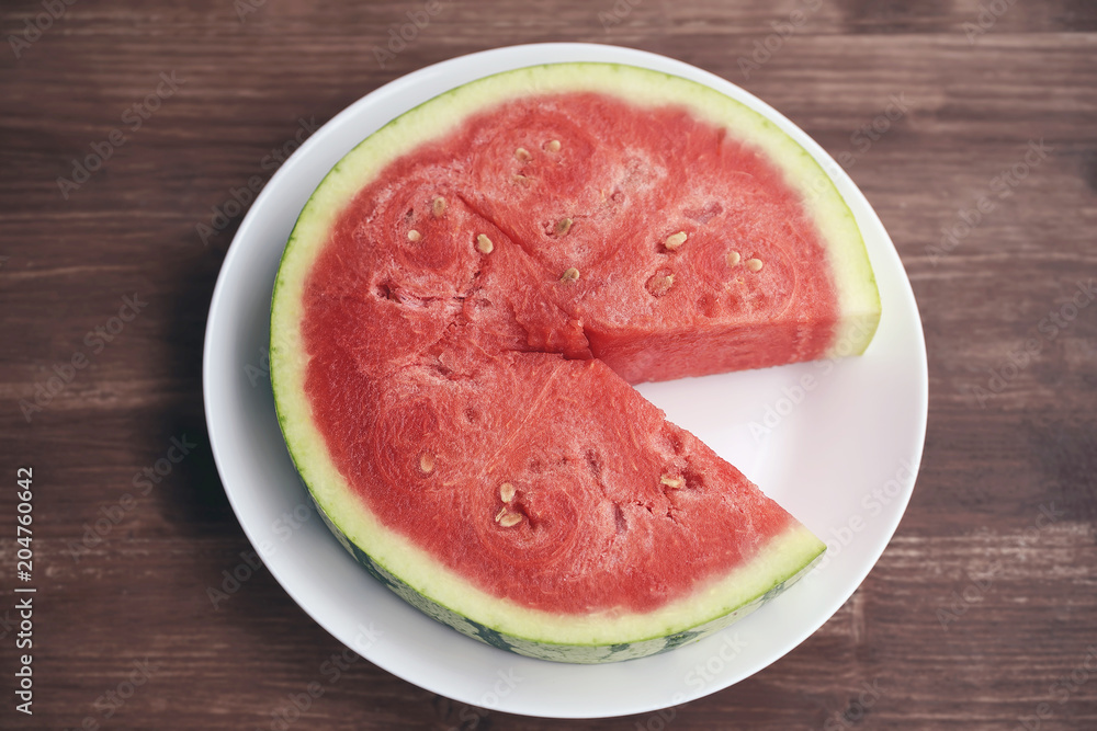 large cut piece of red juicy fresh watermelon is appetizingly lying on a white plate. large cut piece of red juicy fresh watermelon is appetizingly lying on a white plate.
