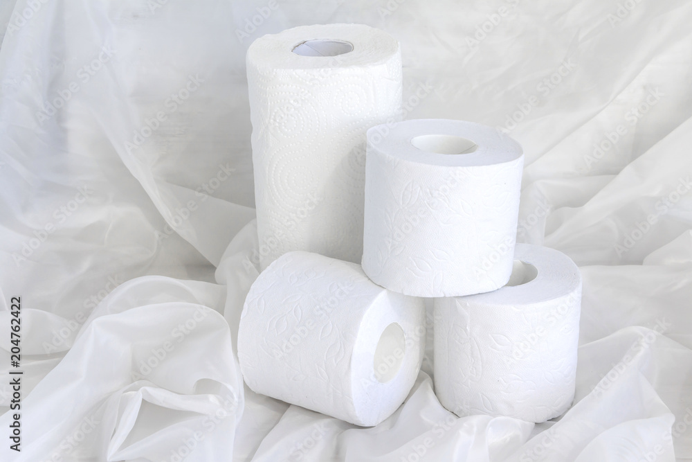 White paper towel rolls, toilet paper stack on draped cloth. White paper towel rolls, toilet paper stack on draped cloth.