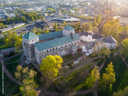 Aerial view of Turku Castle at morning sun with green springtime trees and park in Turku, Finland