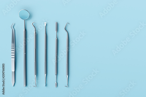 Dentist tools on pastel blue background.