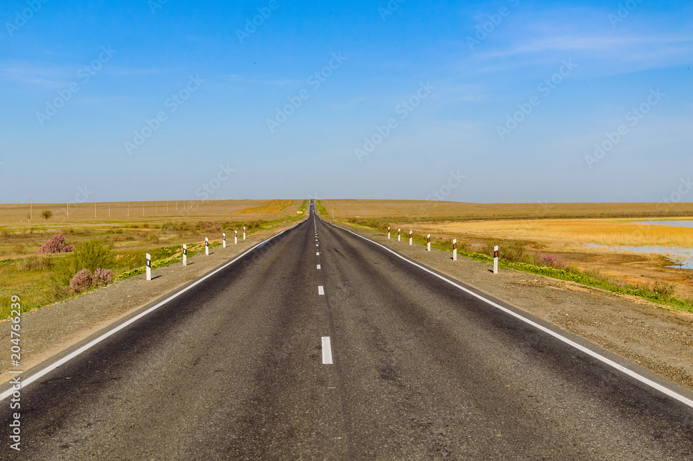 The picturesque landscape and blue sky over road. Asphalt road with marking