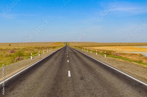 The picturesque landscape and blue sky over road. Asphalt road with marking