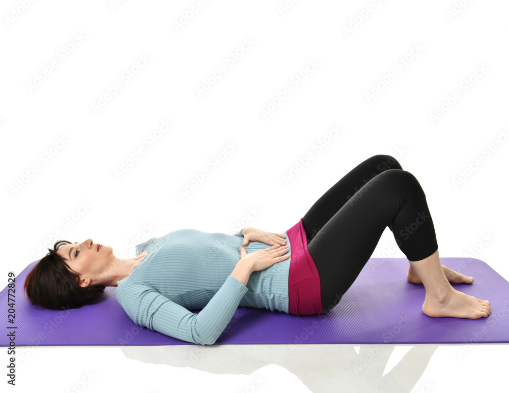 Mother woman exercising doing postnatal workout. Female fitness instructor holds legs in gym and workout exercises Mother woman exercising doing postnatal workout. Female fitness instructor holds legs in gym and workout exercises