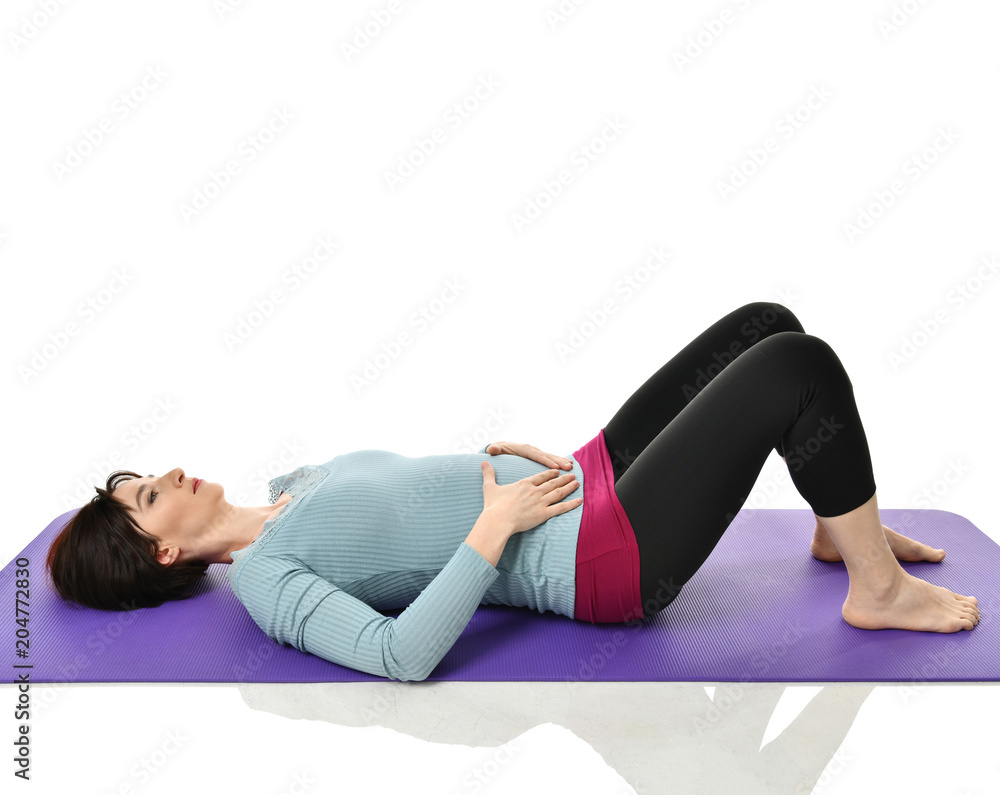 Mother woman exercising doing postnatal workout. Female fitness instructor holds legs in gym and workout exercises Mother woman exercising doing postnatal workout. Female fitness instructor holds legs in gym and workout exercises
