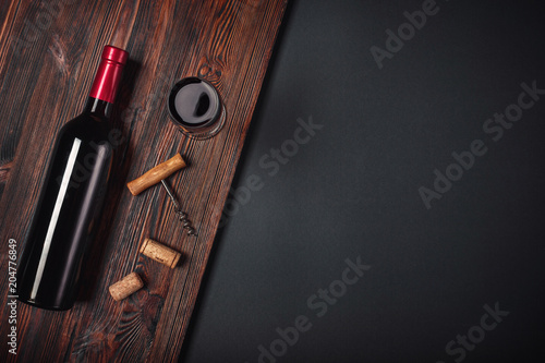 Bottle of wine corkscrew and wineglass on rusty background