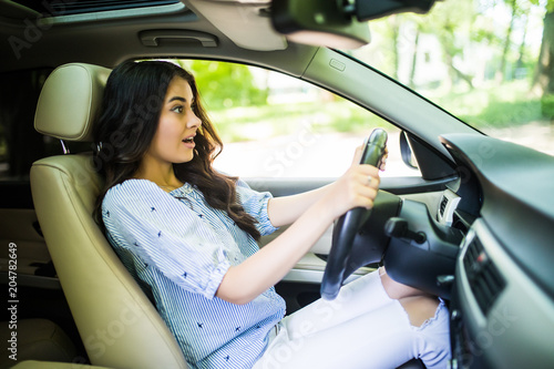 Young frightened driver woman squealing brakes avoiding an accident. Shocked girl tooting horn