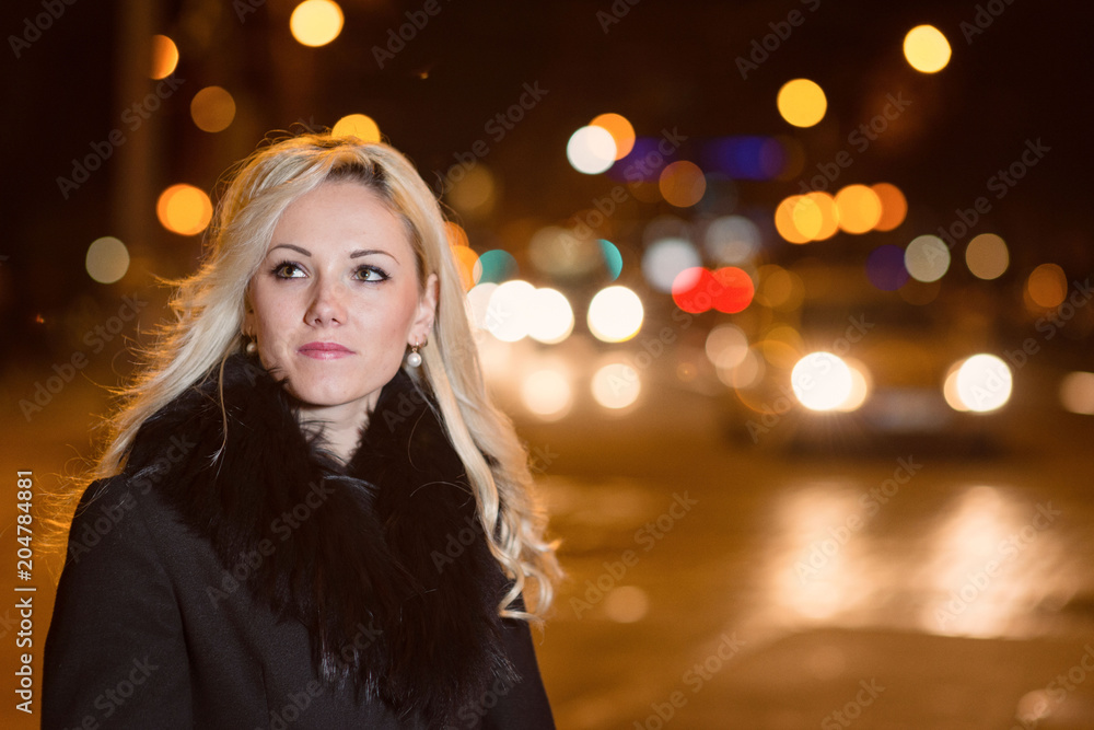 Beautiful, blonde woman in car lights in the night city. Beautiful, blonde woman in car lights in the night city.