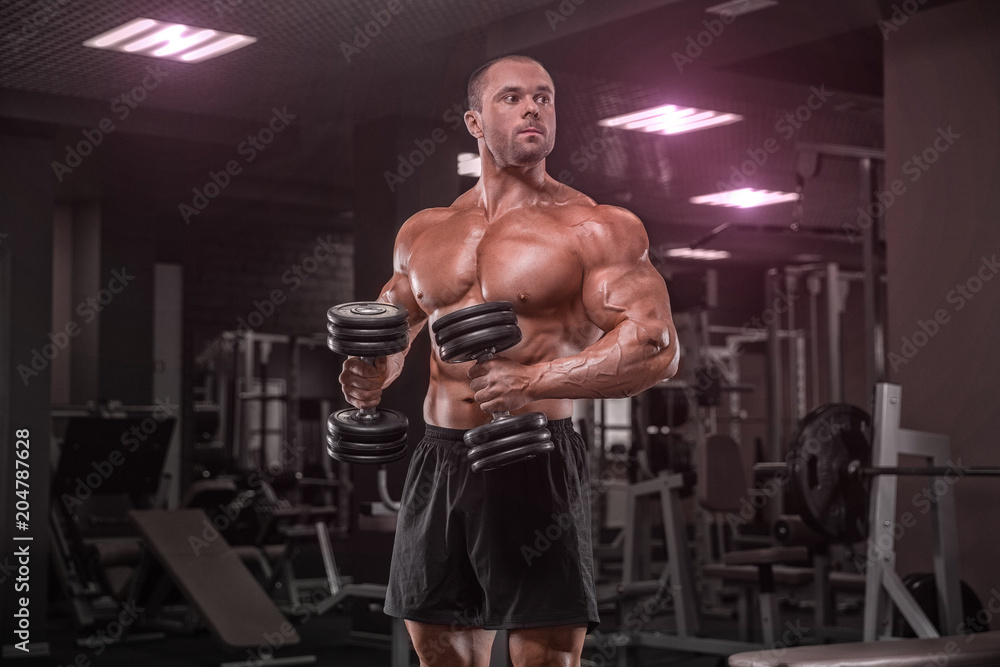 Closeup portrait of professional bodybuilder workout with barbell on black background. Muscular man training squats with barbells over head Closeup portrait of professional bodybuilder workout with barbell on black background. Muscular man training squats with barbells over head