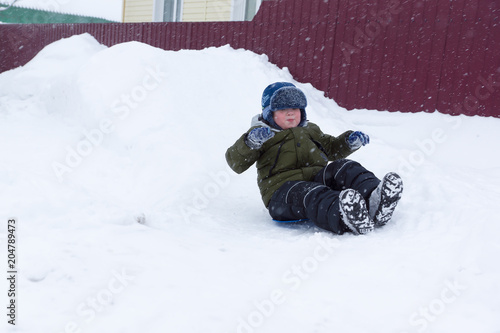 Boy goes for a drive on a snowy hill