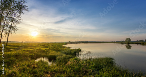 летний вечерний пейзаж на Уральской реке с деревьями на берегу, Россия, июнь photo