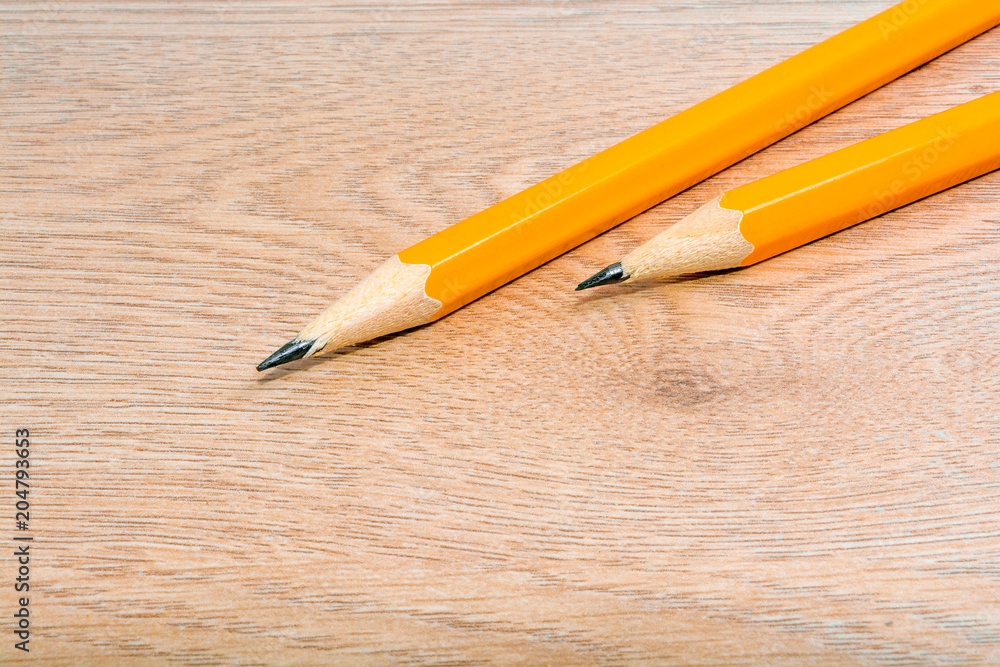 Two sharpened pencils on a wooden table. Stationery close-up. Back to school. Copyspace. Office tool. Two sharpened pencils on a wooden table. Stationery close-up. Back to school. Copyspace. Office tool.