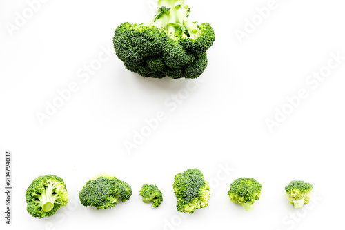 Layout of fresh uncooked broccoli on white background top view copy space