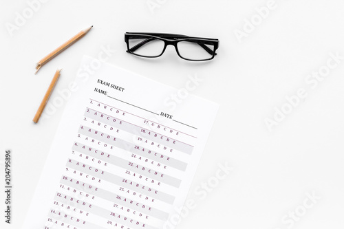 Exam sheet on white table flat lay space for text. Education concept