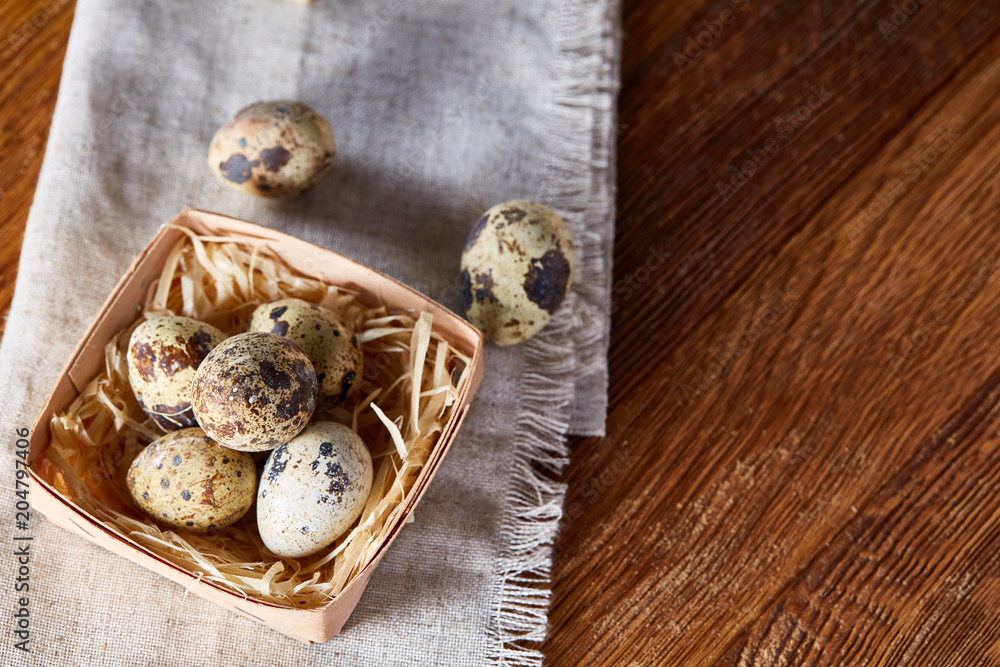 Quail eggs in the container over rustic wooden table, close-up, high angle view, selective focus. Quail eggs in the container over rustic wooden table, close-up, high angle view, selective focus.