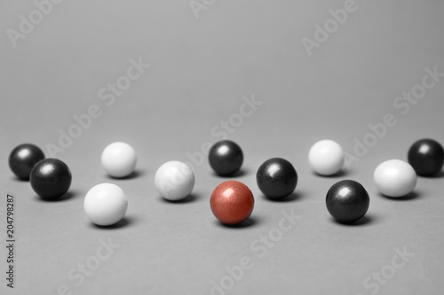 Decorative balls and one different on grey background