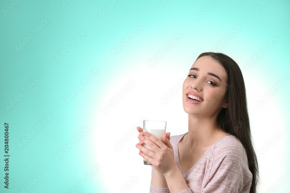 Beautiful young woman drinking milk on color background Beautiful young woman drinking milk on color background