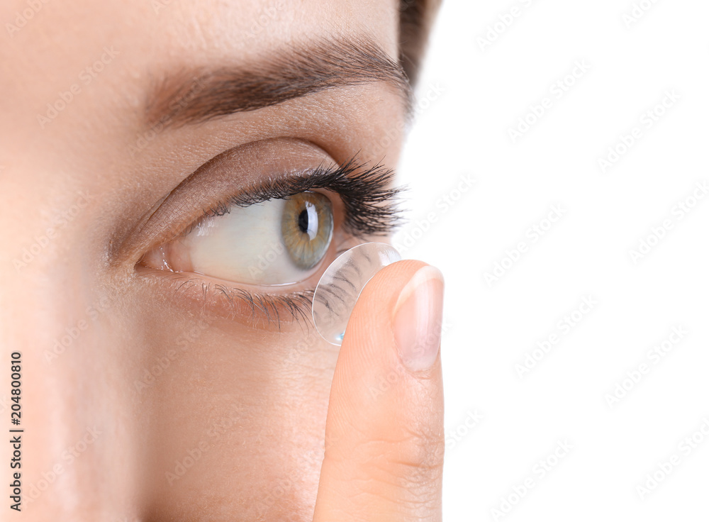 Fototapeta premium Young woman putting contact lens in her eye, closeup
