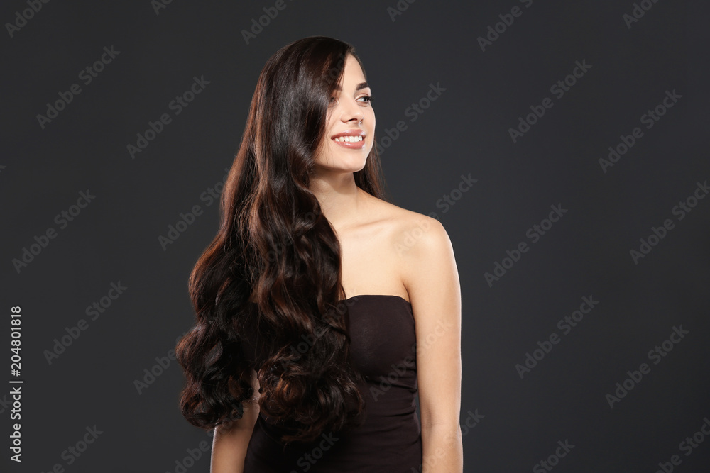 Naklejka premium Portrait of beautiful model with gorgeous curly hair on black background