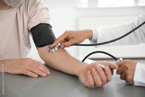 Doctor measuring patient s blood pressure in hospital