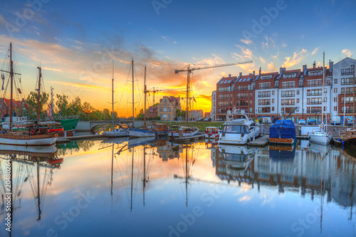 Beautiful marina with yachts in Gdansk reflected in the river at sunrise, Poland.