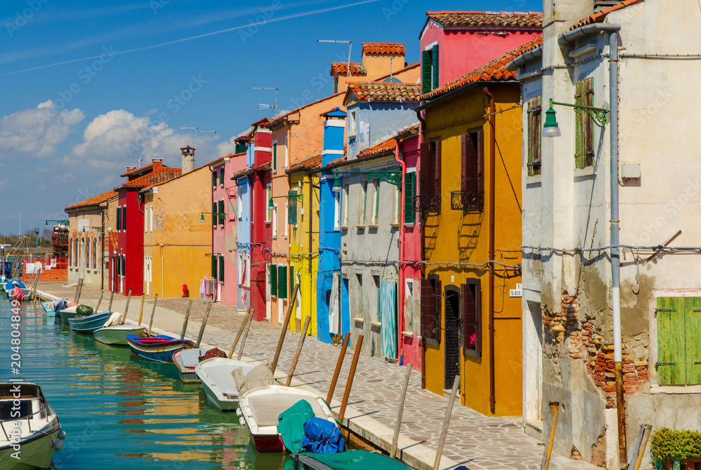 Colorful houses and boats docked at Burano near Venice.