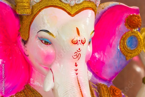 Fototapeta Naklejka Na Ścianę i Meble -  Close up of God Ganesh colorful image with the Om symbol on the face.