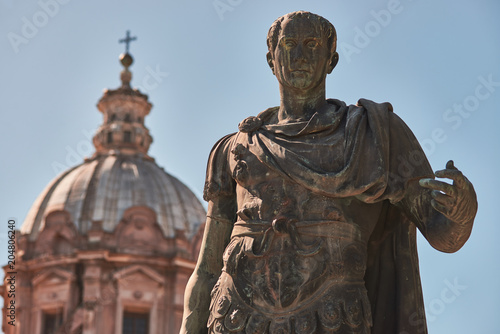 Foto Rome, Bronze statue of emperor Julius Caesar, in the background the dome of  Sai
