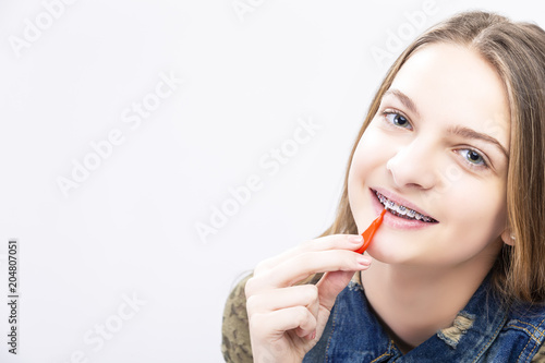 Dental Health Ideas and Concepts.Closeup Portrait of Caucasian Female Teenager With Teeth Braces. Cleaning Brackets Using Bristle Brush.