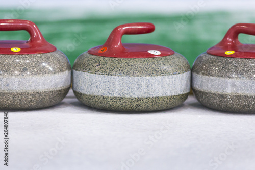Sport Concepts. Closeup of Curling Blue Handle Stones on Ice.With Copyspace.