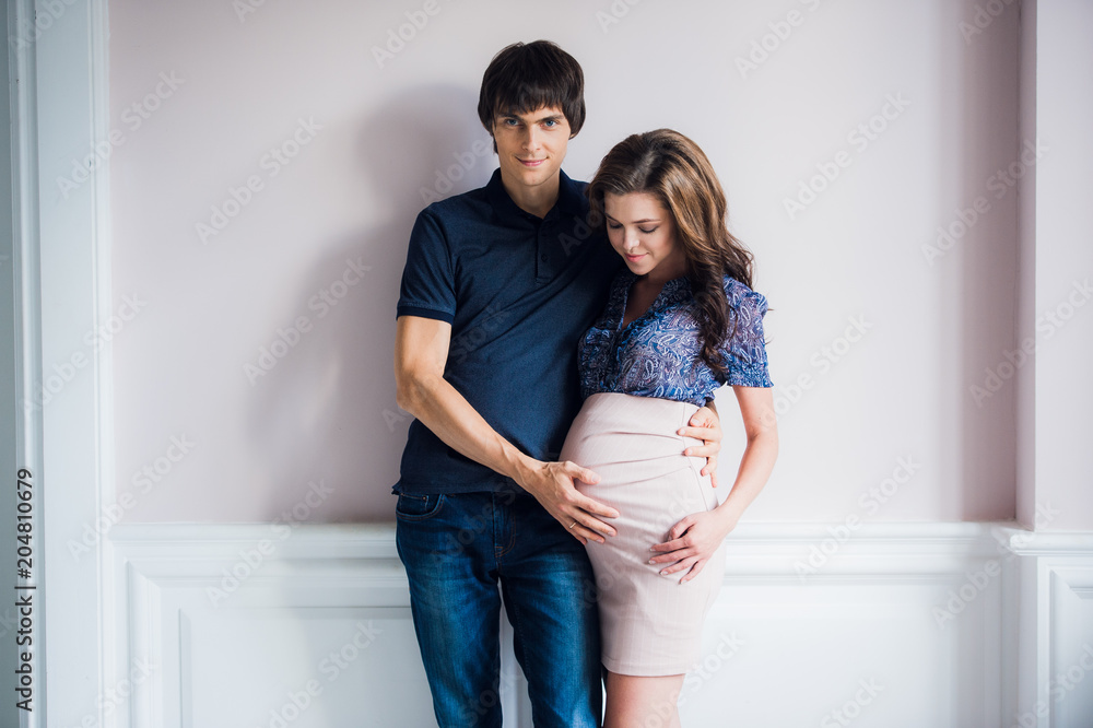 Man kissing his pregnant wife and touching her belly Man kissing his pregnant wife and touching her belly