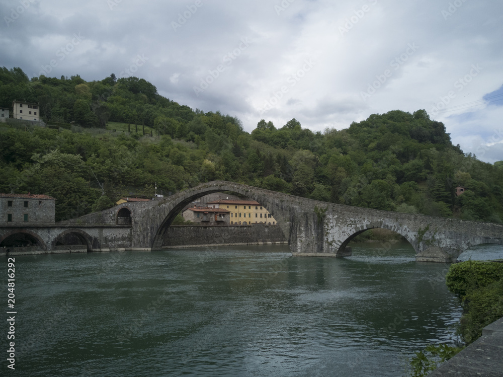 Stone arch bridge from the 14th century over the river Serchio Ponte della Maddalena