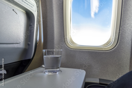 Glas mit Mineralwasser an Bord eines Flugzeugs