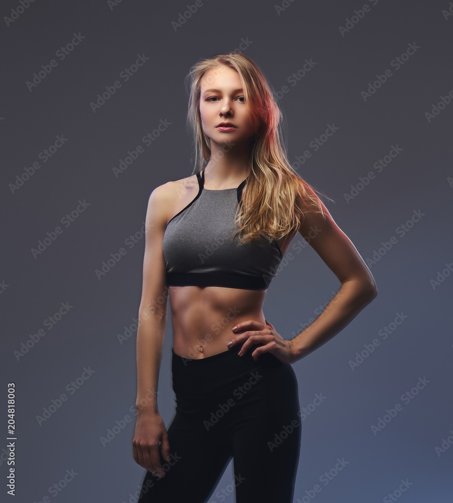Sexy slim blonde girl in a sportswear posing in a studio. Sexy slim blonde girl in a sportswear posing in a studio.