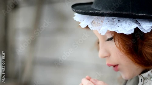 Portrait of a red-haired girl in ethnic clothes and in a hat with lace. photo