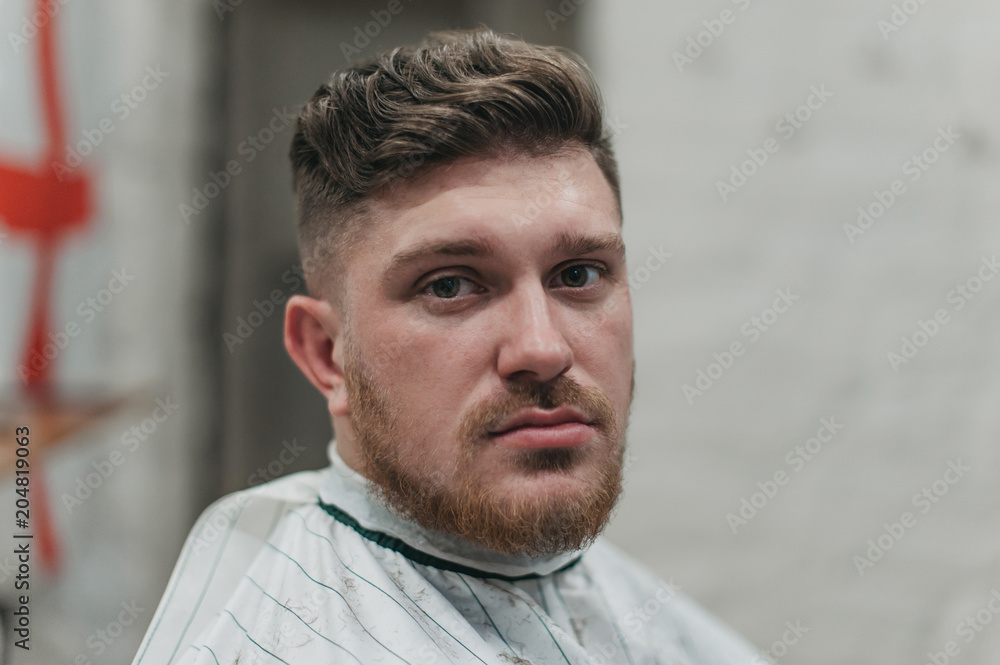 Obraz premium A man in a barber shop for haircuts and shaving