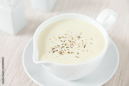 Frische hausgemachte Bechamelsauce aus Butter, Mehl und Milch, eine klassiche helle Grundsauce (Selektiver Fokus, Fokus in die Mitte des Bildes)
