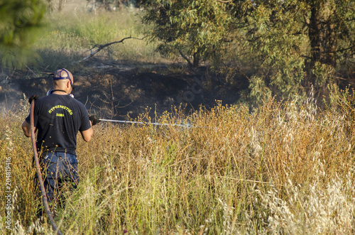 Firefighter fire extinguishing field with dry grass