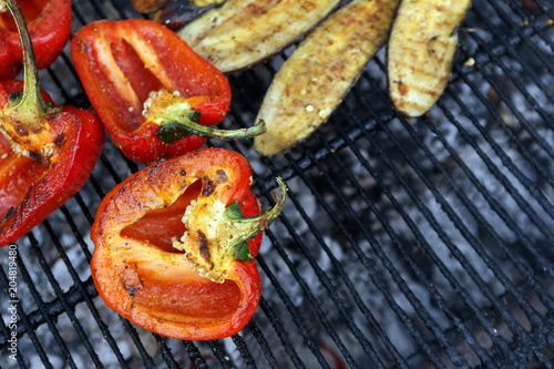 Close-up red pepper and slices of eggplant are grilled. Open fire kitchen. BBQ Restaurant. Red grilled pepper on bbq fireplace